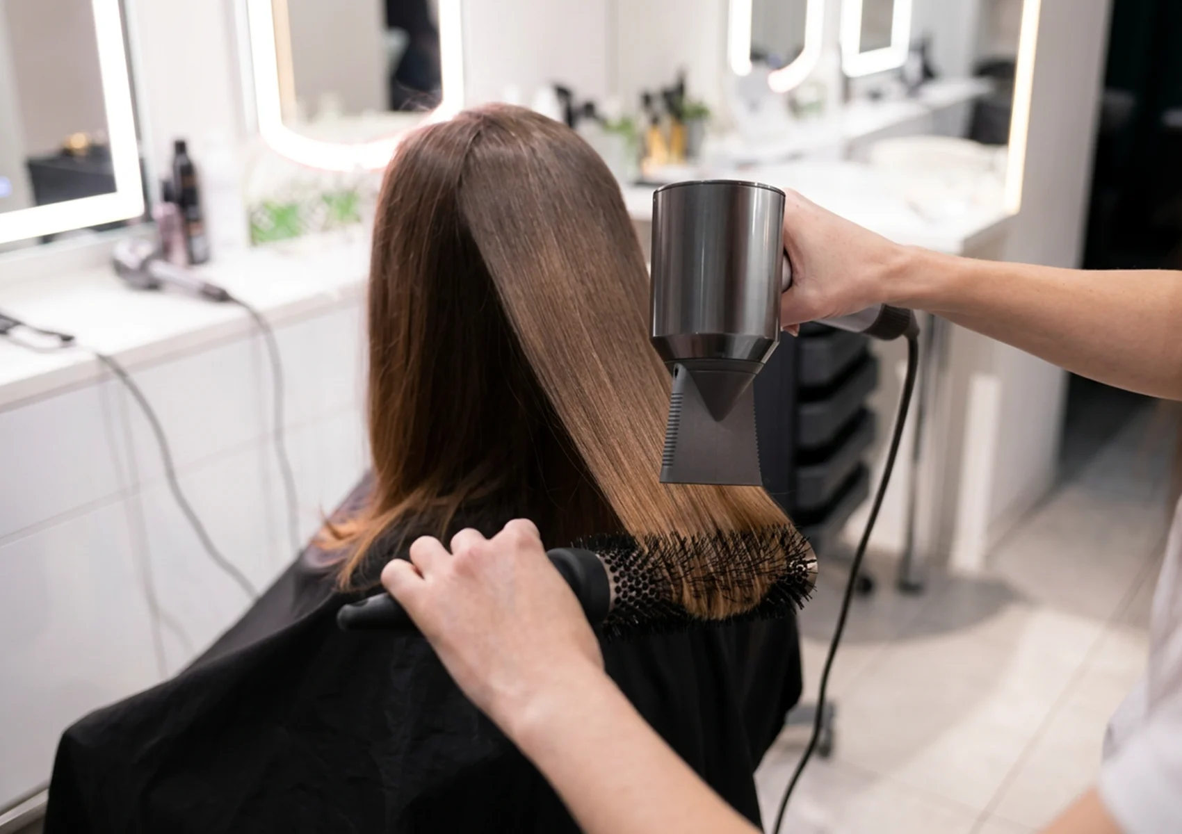Professional hair blow dry treatment for coloured hair in Bali to reduce humidity frizz, smooth flyaways, and maintain healthy shiny hair in a modern salon setting