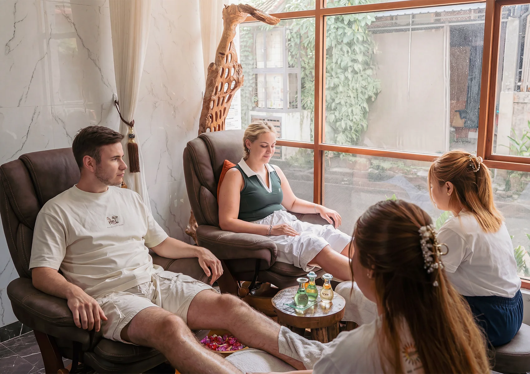Couples massage and spa treatment in Ubud with relaxing foot therapy, comfortable lounge chairs, and a peaceful wellness atmosphere in Bali